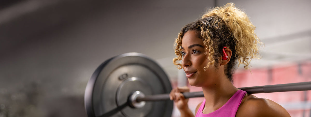 Athlete training with JLab GO Sport ANC earbuds in vivid pink